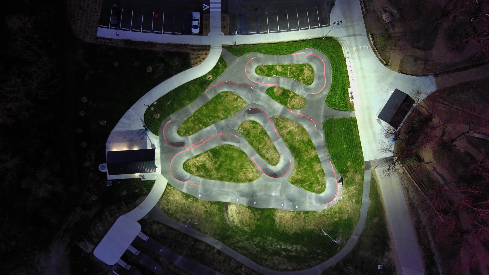 Aerial drone image looking down at the Pump Track lit up at night