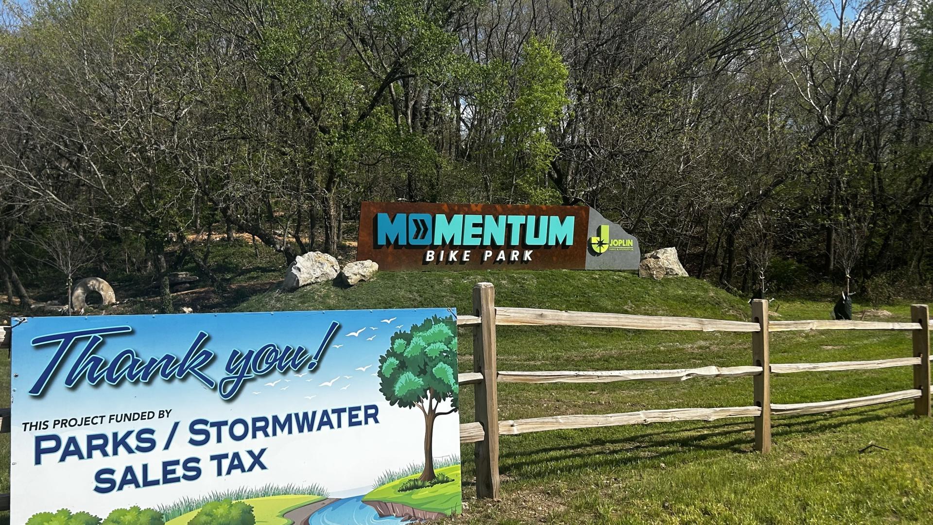 Banner reading "Thank you! This Project funded by parks/stormwater sales tax" hangs on fence at MOmentum