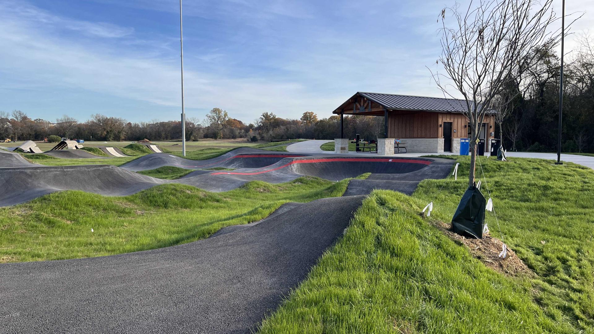 Pump track facility with restrooms behind