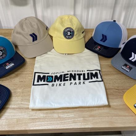 MOmentum branded hats and shirt displayed on a table