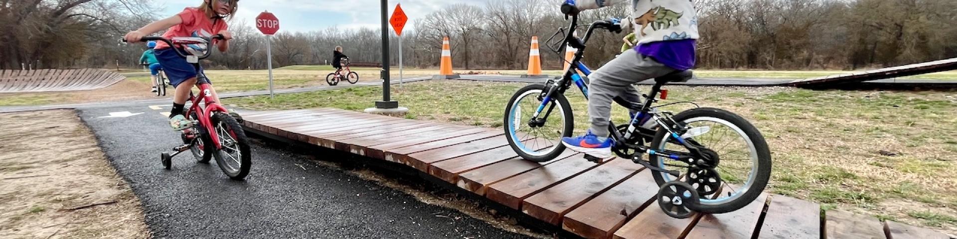 kids on bikes with training wheels in the bicycle playground