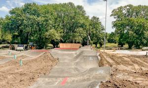 Biking track under construction, surrounded by trees and dirt.