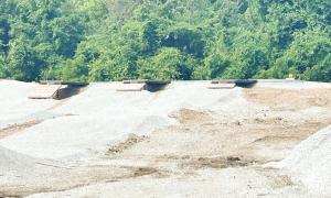 Gravel piles with green trees in the background.